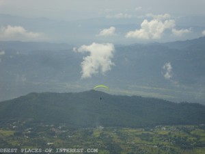 a paraglider flying over the valley.