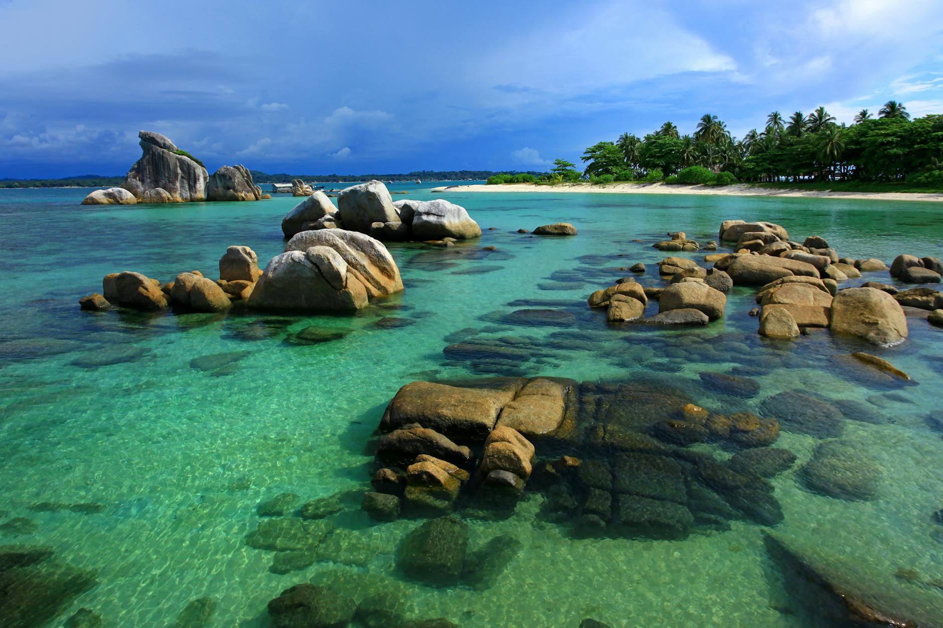 brown rocks in body of water under blue sky. Top Attractions on Belitung Island