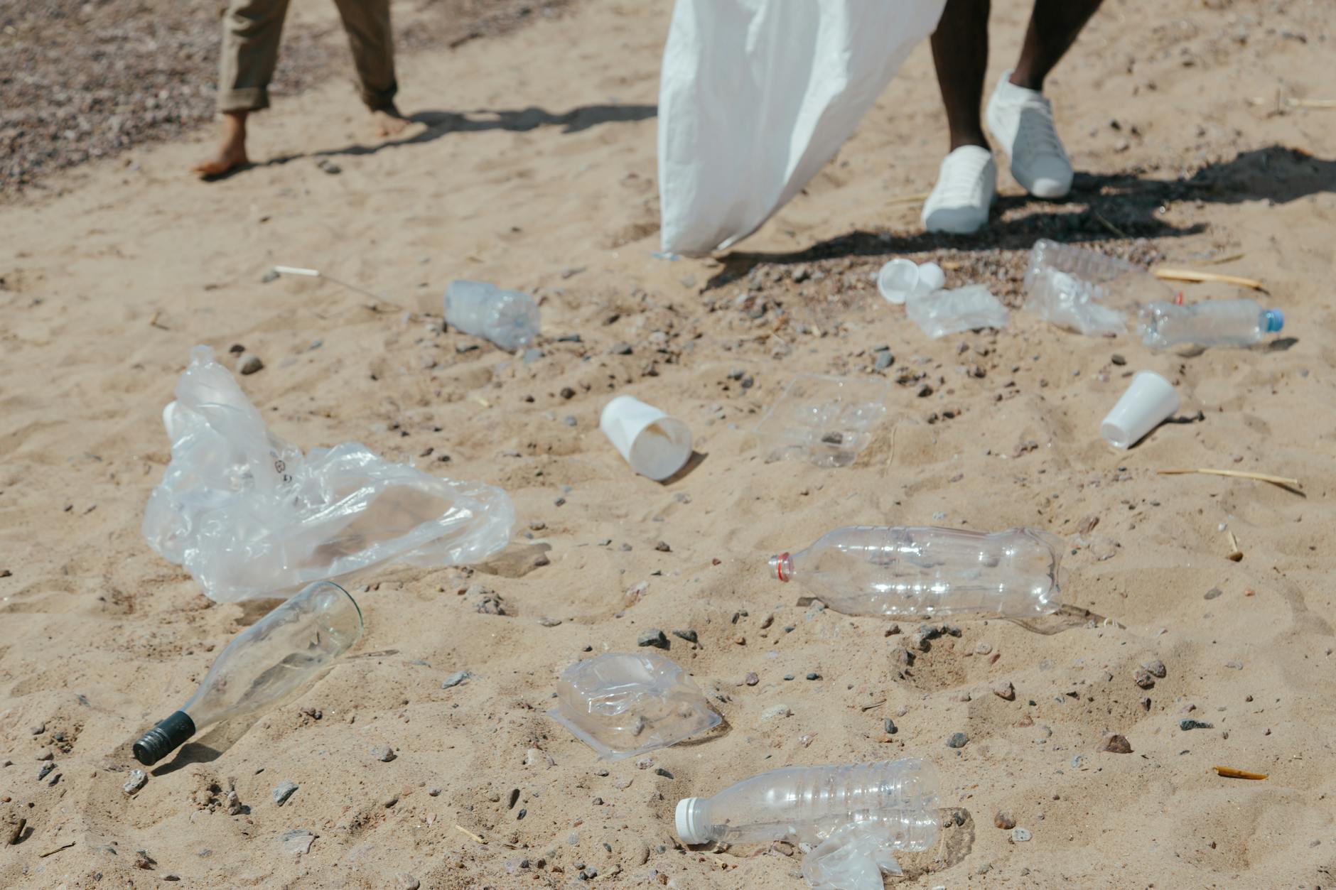 plastic bottles and plastic bags on sand- no to single use plastics on Earth day