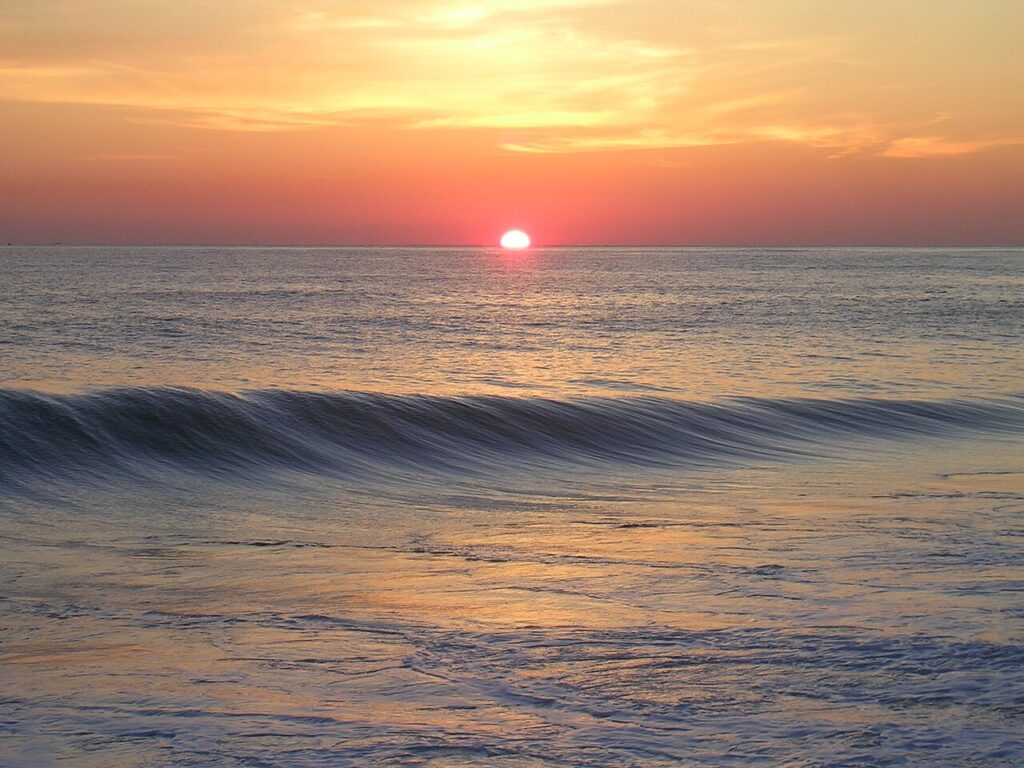 Sunset over ocean symbolizing Reentry with Purpose in mindful investing”