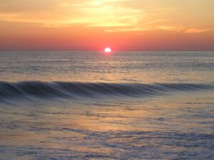 Sunset over ocean symbolizing Reentry with Purpose in mindful investing”