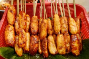 Banana cue skewers caramelized in sugar, a sweet Filipino street food staple in Manila’s night markets.