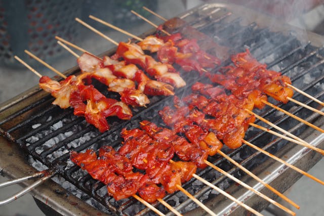 Chiang Mai Thai street food grilled chicken skewers over charcoal