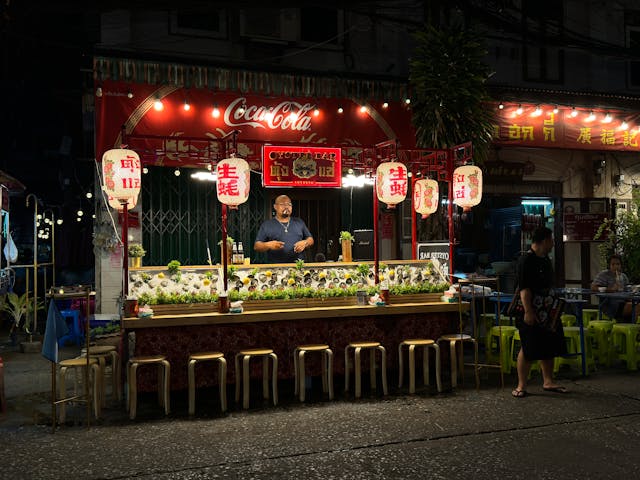 Traditional Thai street food market at night with lanterns in Bangkok