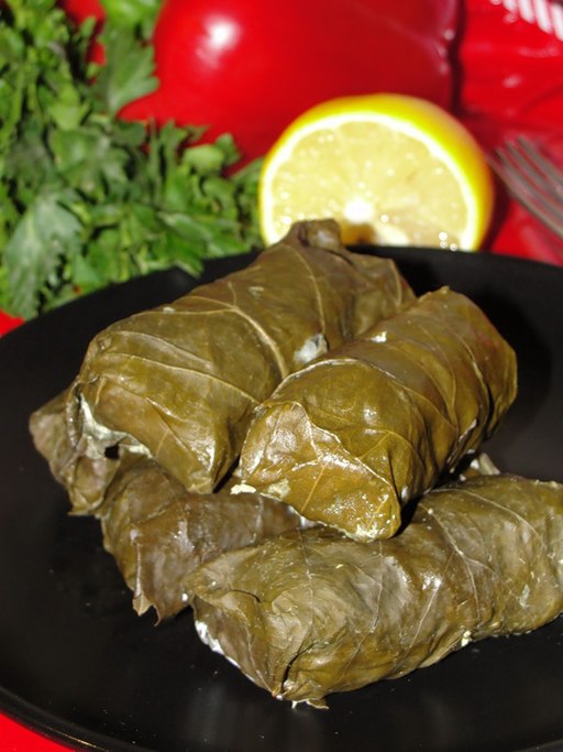 Armenian dolma served on a plate with vine leaves and herbs