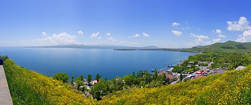Lake Sevan in May with calm blue water and mountains in the background