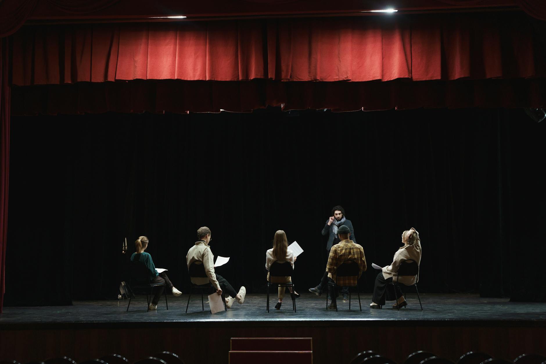group of people sitting on chair on stage- World theatre day