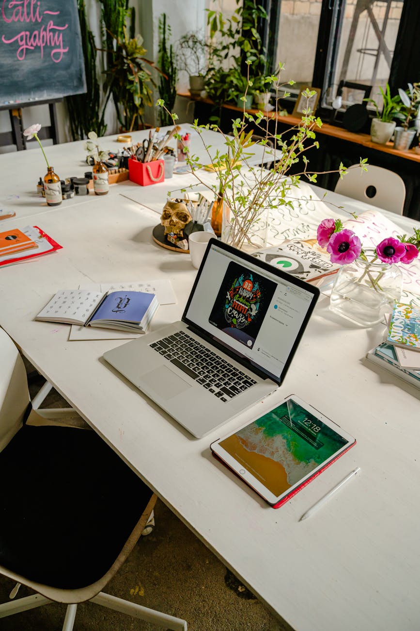 laptop and a tablet on white wooden table. Work with us