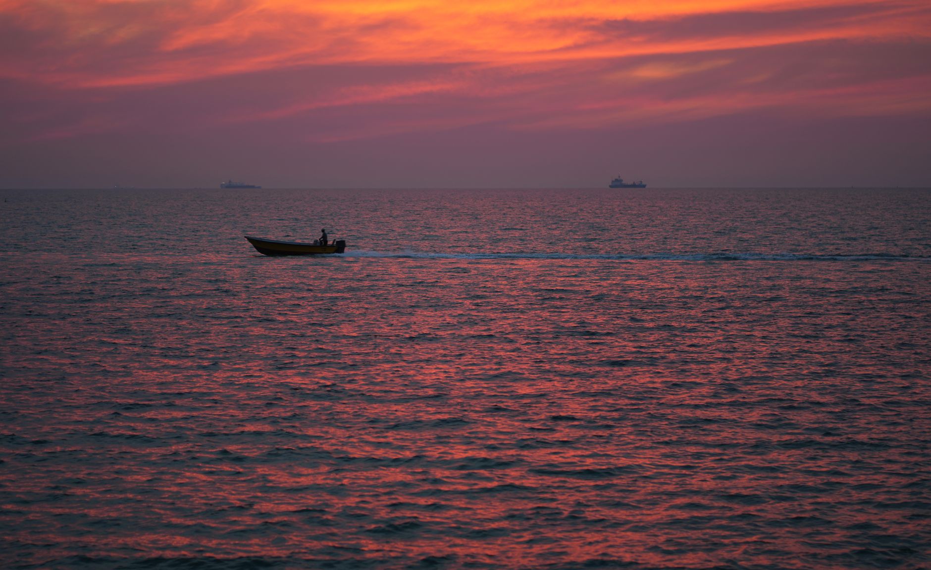 silhouette of motorboat on sea at dusk. calm travel destinations Maldives Red Sea Okinawa