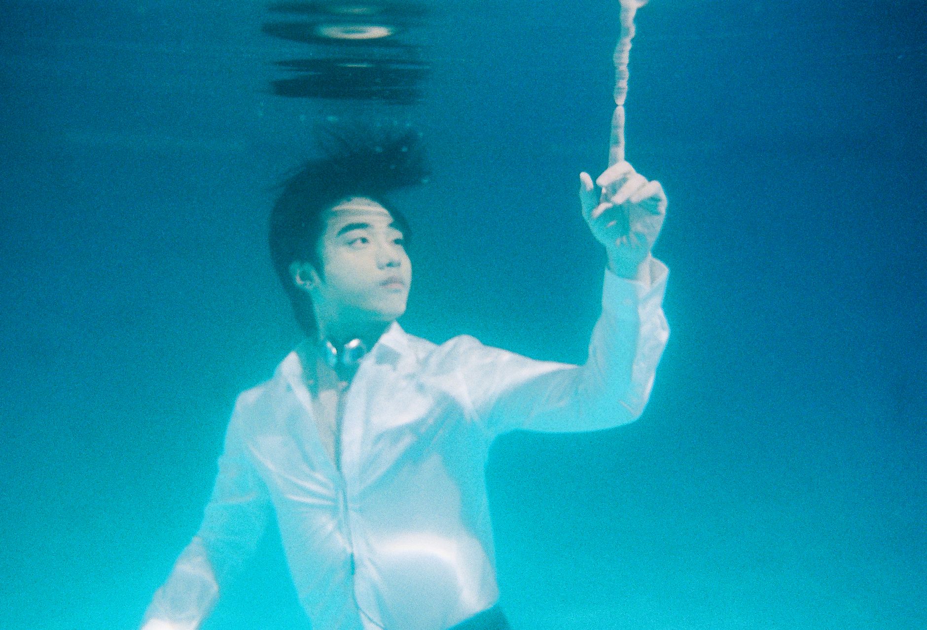 underwater portrait of man reaching upward. monsoon break underwater calm india