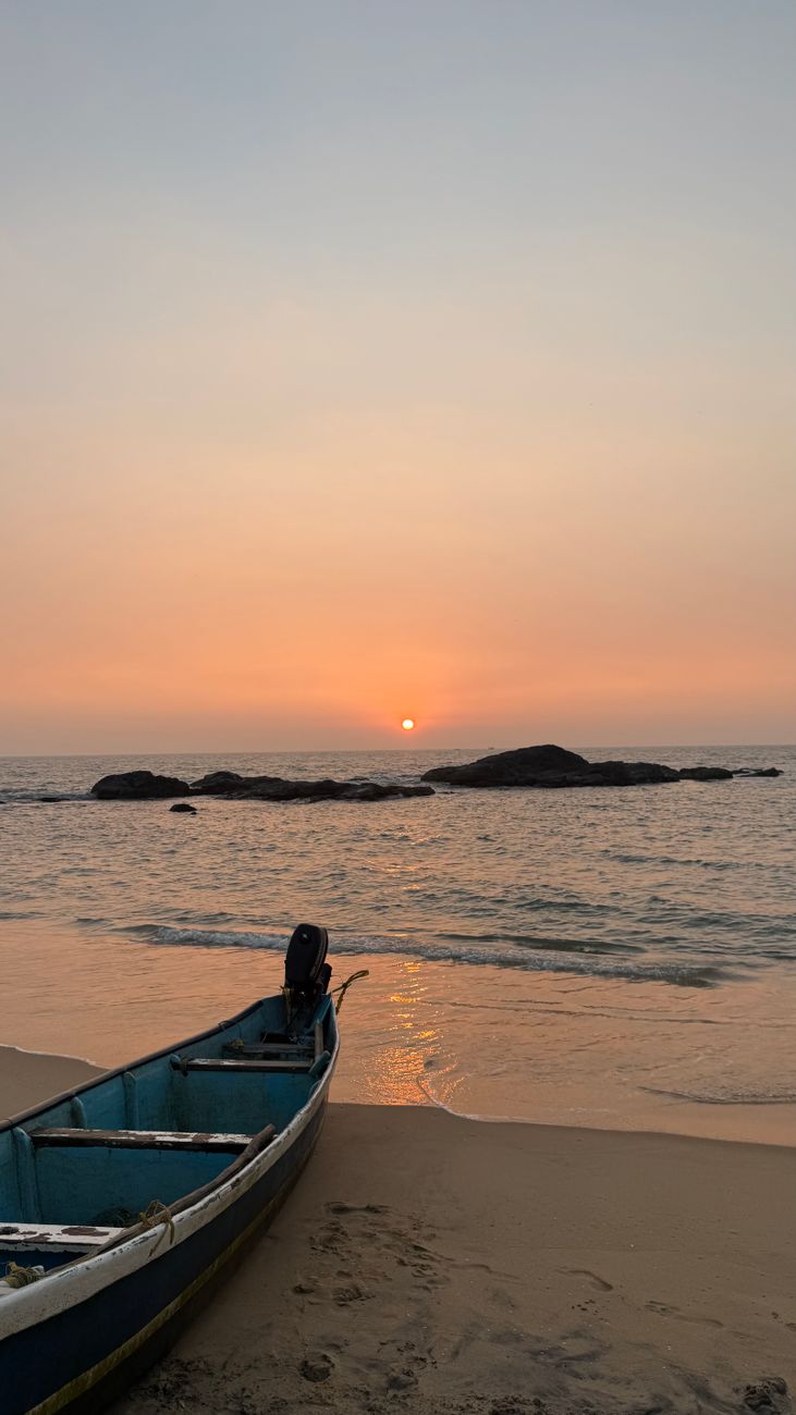 tranquil sunset with abandoned boat on beach. El Niño monsoon break snorkeling India Karwar beach clarity