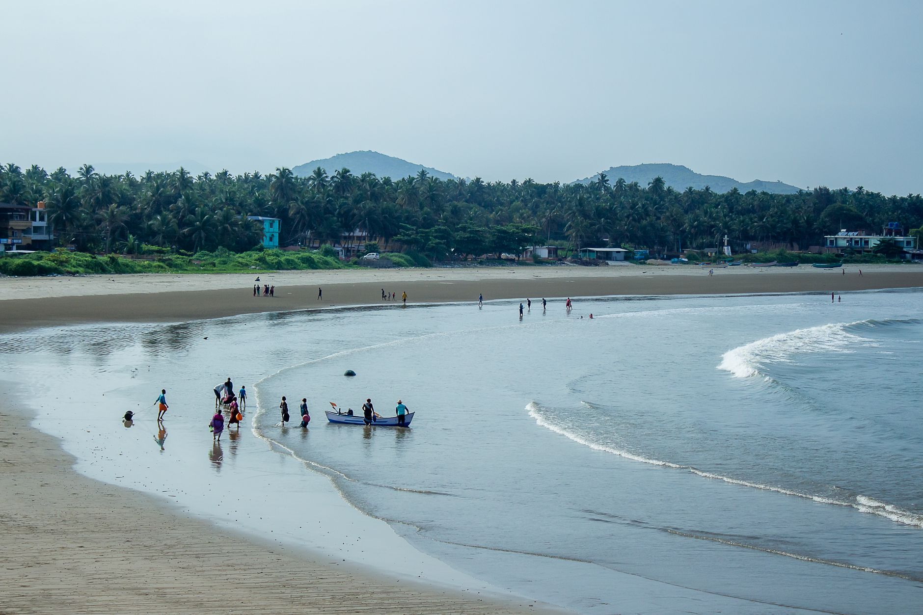 beach scene with fishermen returning at daytime. El Niño monsoon break snorkeling India Murudeshwar fishermen returning