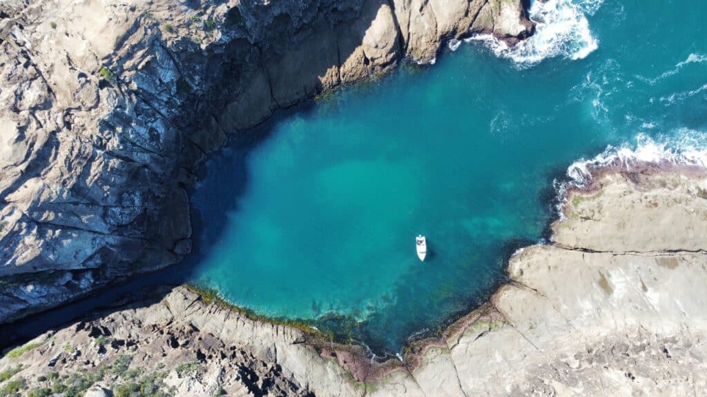 Underwater blue lagoon with cliffs and filtered light, capturing the calm before a deep descent