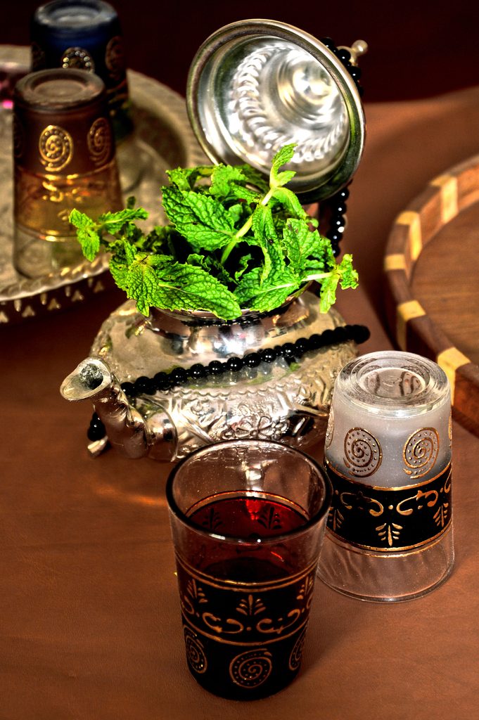 Traditional Moroccan mint tea served in glasses with fresh mint, offering a cool, refreshing note within a warm desert palette.
