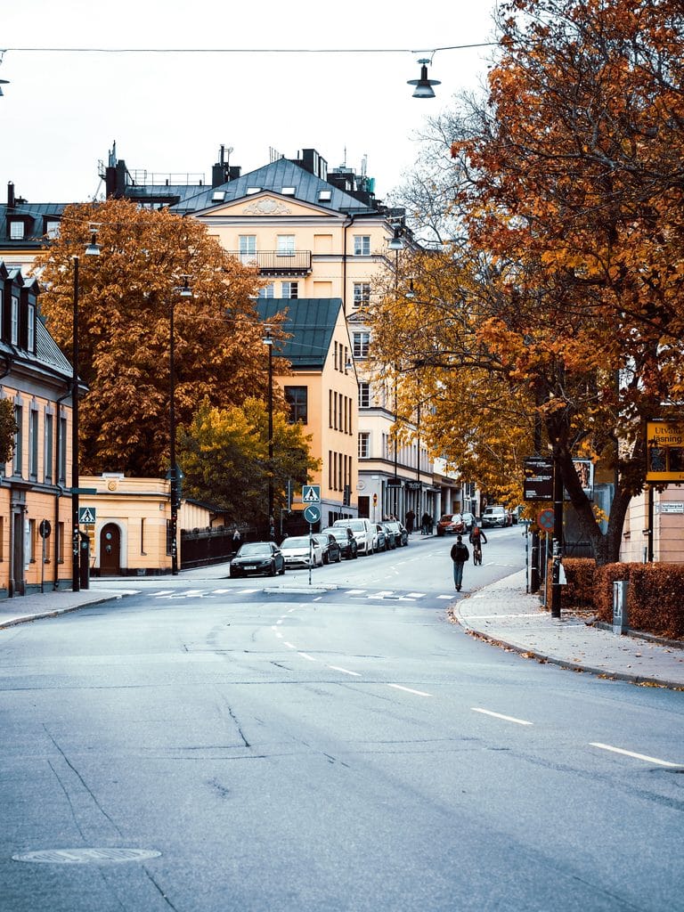 Autumn street scene in Stockholm with soft Scandinavian light, pastel buildings, and early‑season calm.