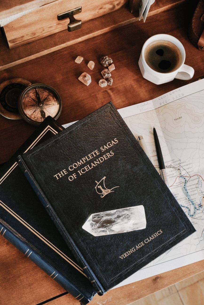 Books and a warm cup of coffee on a wooden table, reflecting the calm, quiet mood of Icelandic literature.