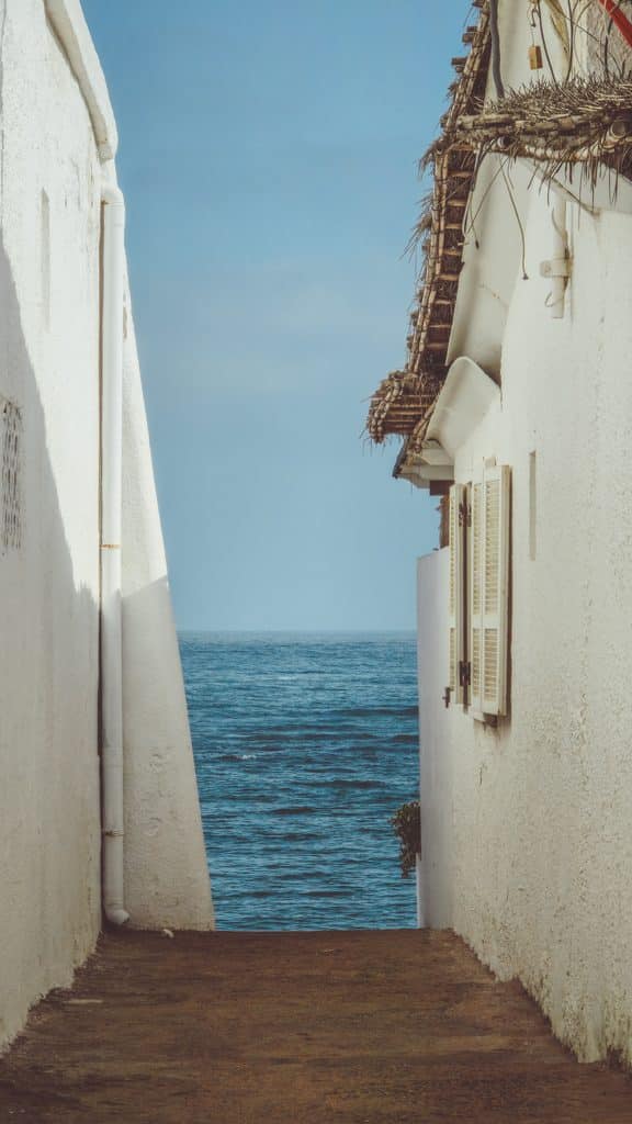 Coastal alleyway with white walls and Mediterranean Sea views in Tunisia