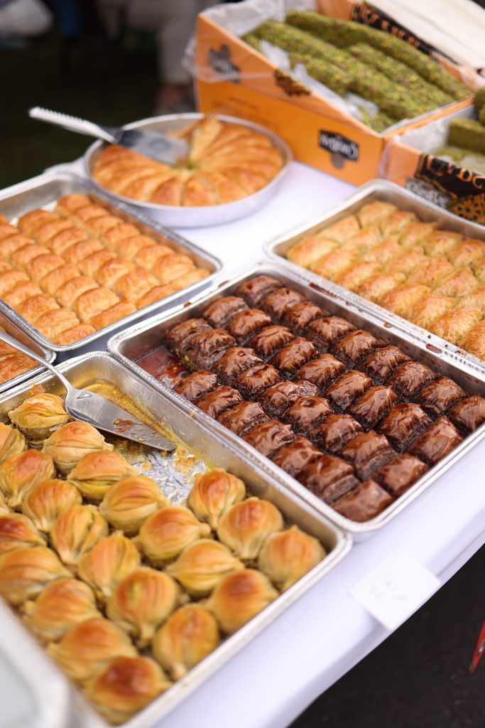 Assorted baklava pastries displayed in trays at a traditional bakery.